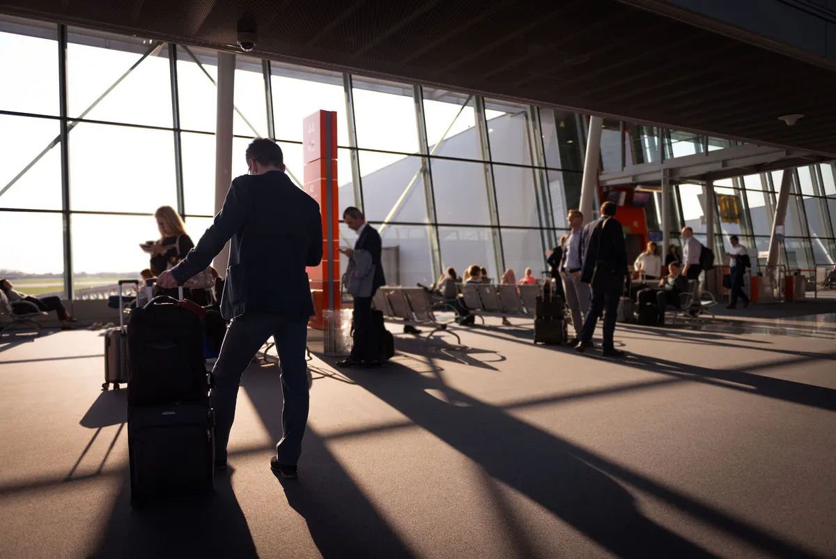 Travellers with their bags in a bright airport terminal