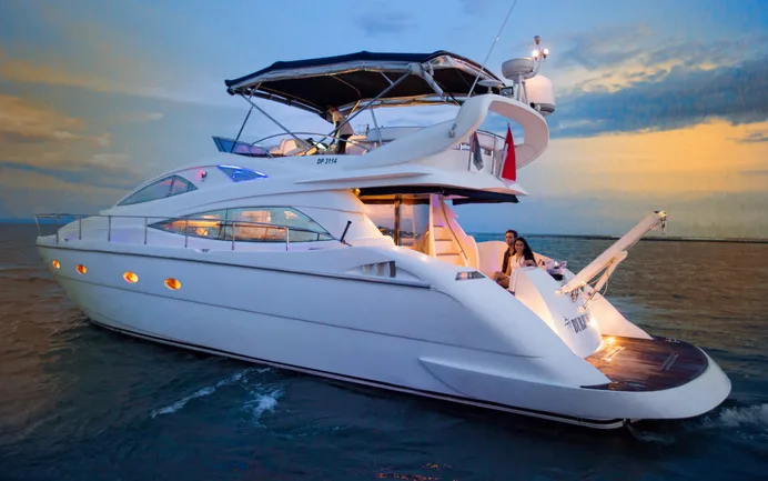 A white flybridge motor yacht at sea at sunset