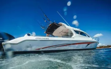 A white speedboat-style motor yacht on blue water