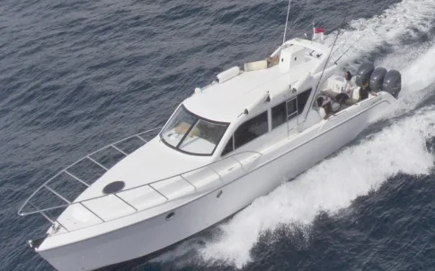 A white motor yacht at speed, seen from above