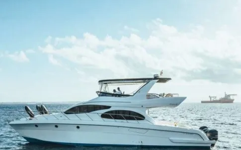 A white 17-metre motor yacht with a flybridge at sea