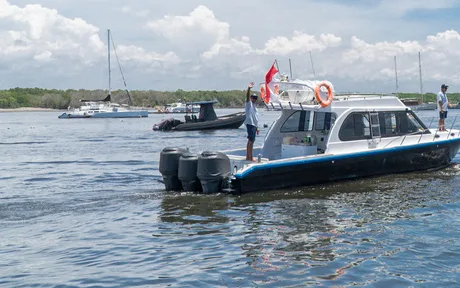 A dark sports cruiser leaving a harbour